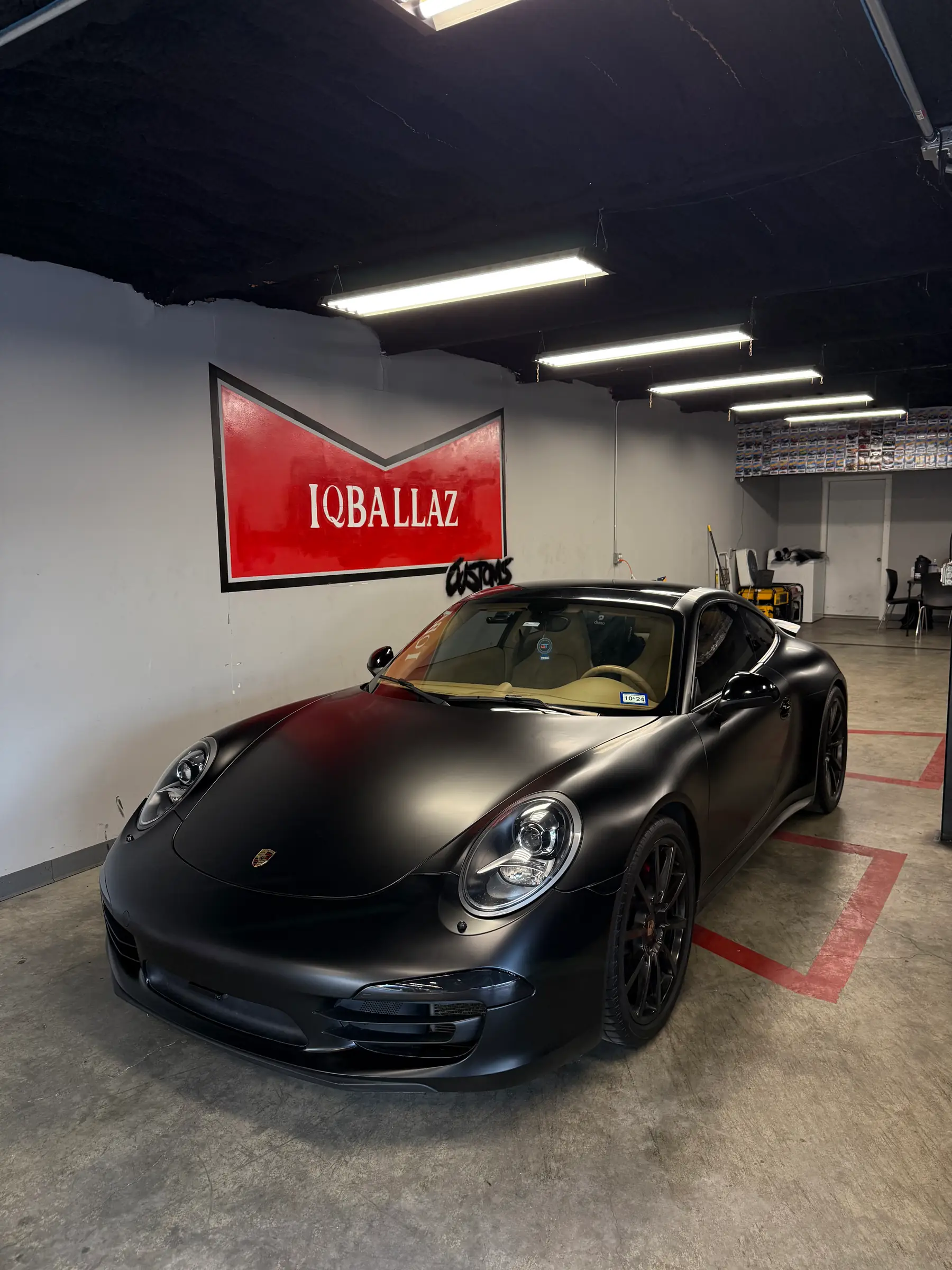 Porsche 911: Matte Black wrap, front three-quarter