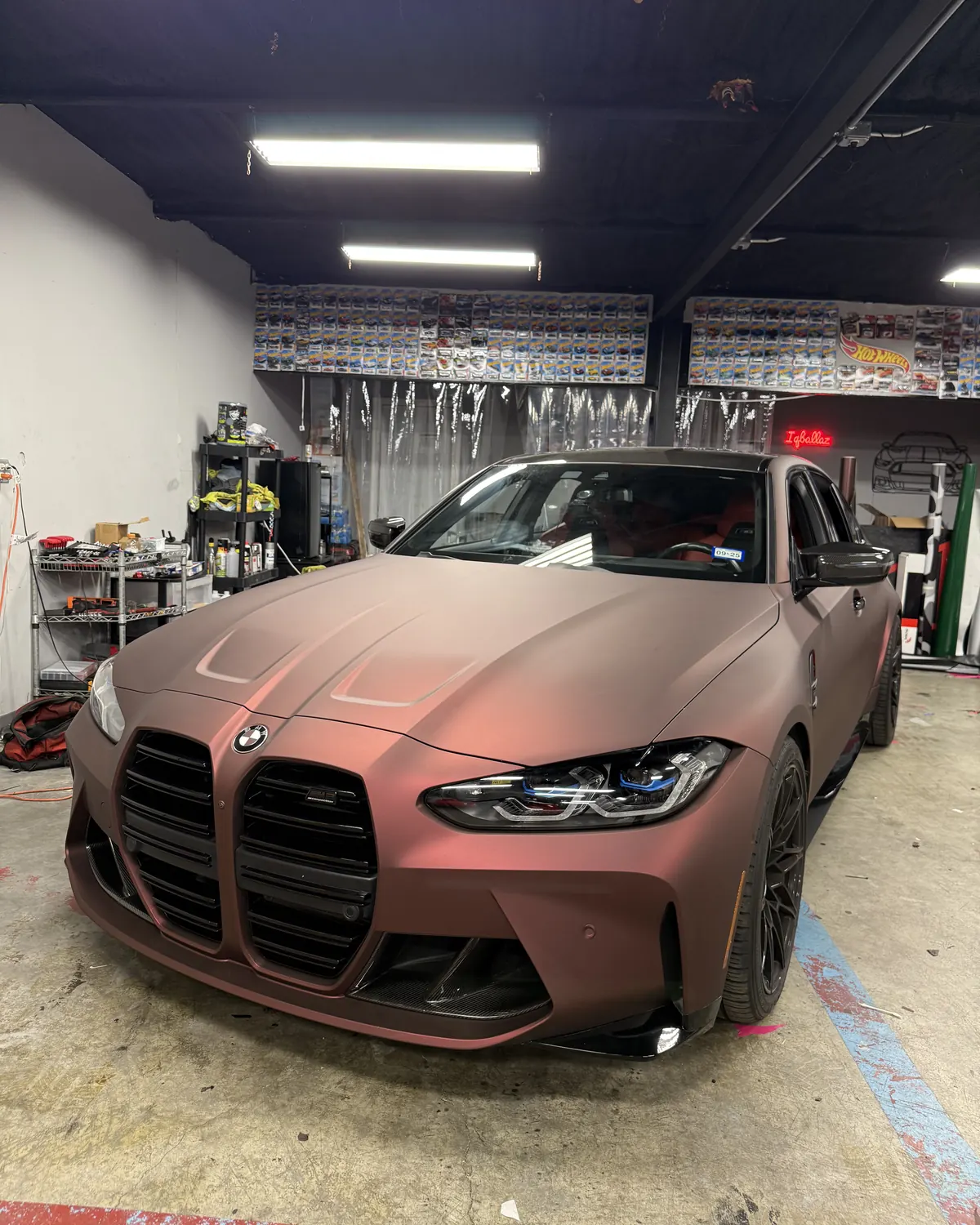 BMW M3 in a matte rose wrap on the shop floor