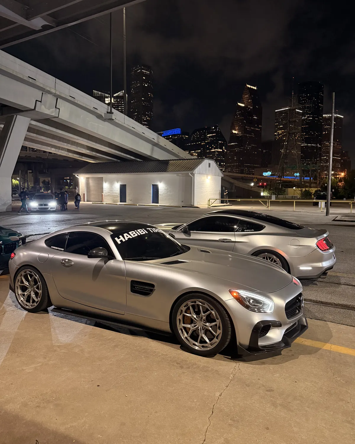 Satin silver Mercedes-AMG GT under the Houston skyline
