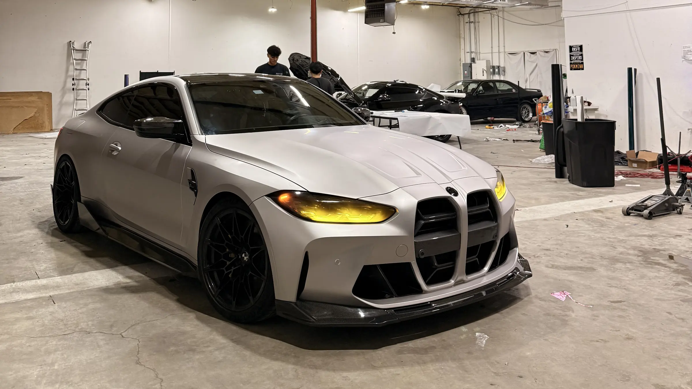 BMW M4 in a satin grey wrap on the Iqballaz Customs shop floor