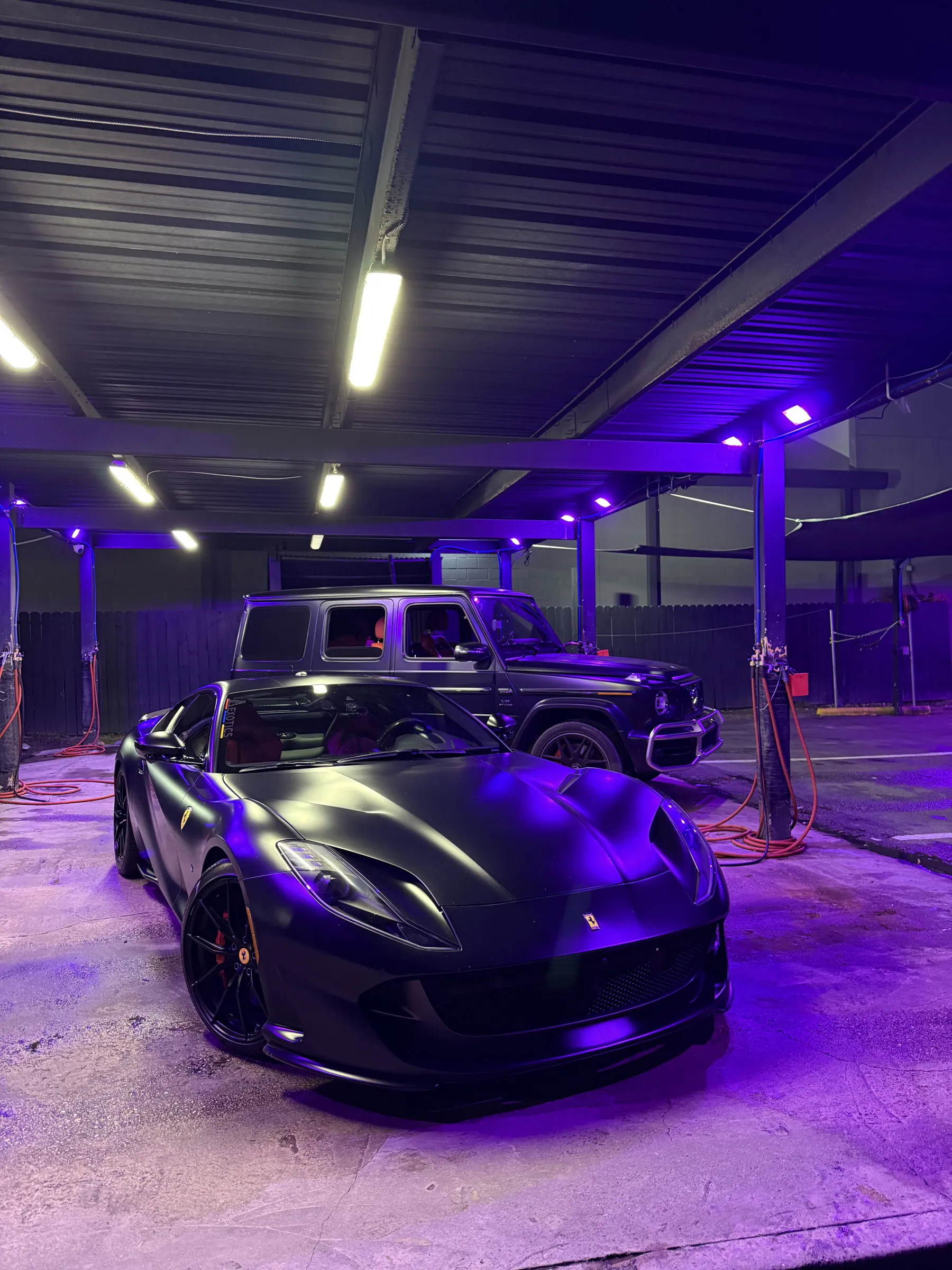 Wrapped vehicles under studio lighting in the Iqballaz Customs Houston shop
