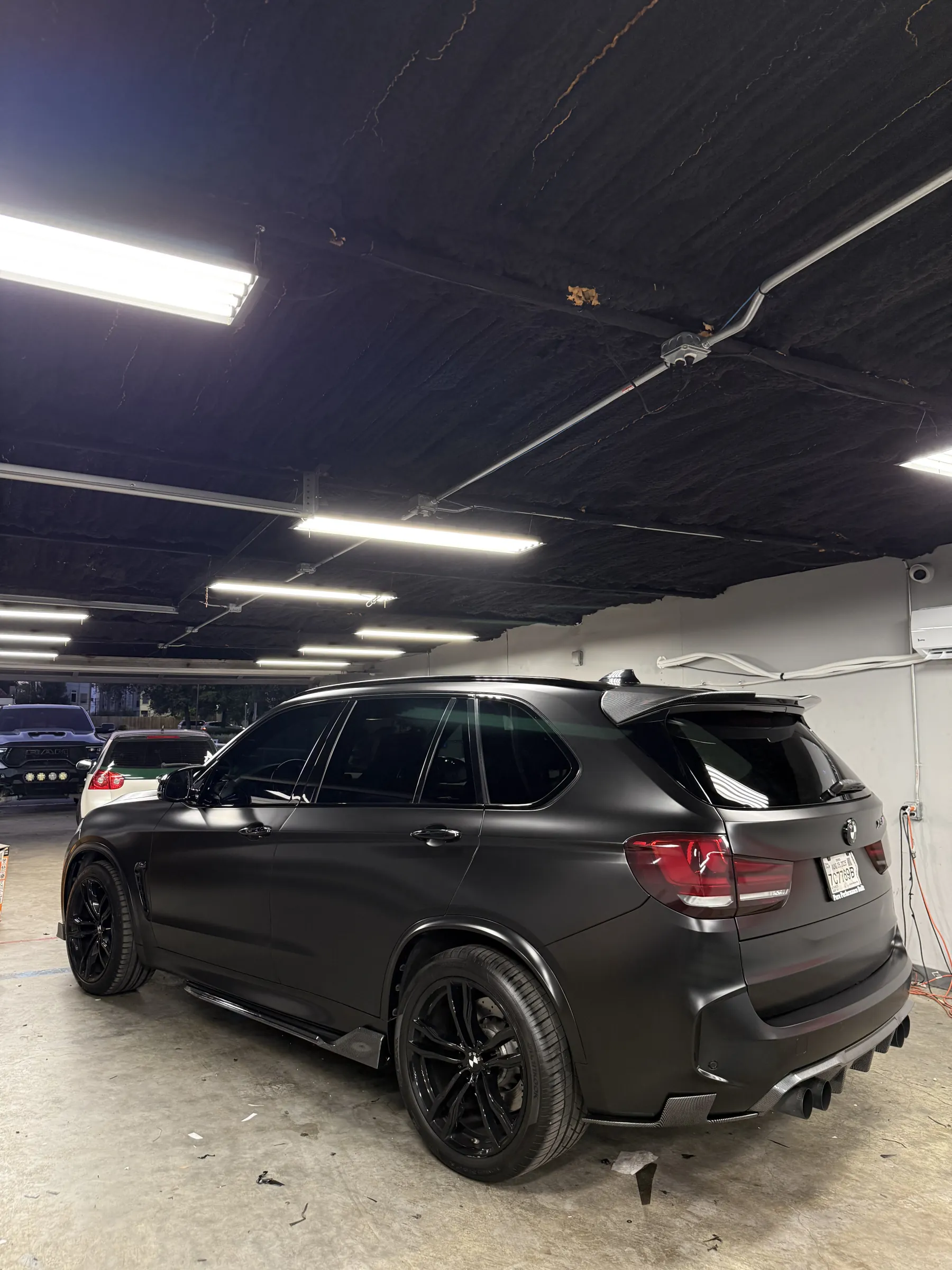 BMW X5 M in satin black inside the Iqballaz Customs shop